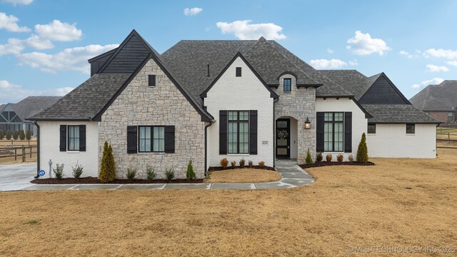 french country style house featuring a front yard