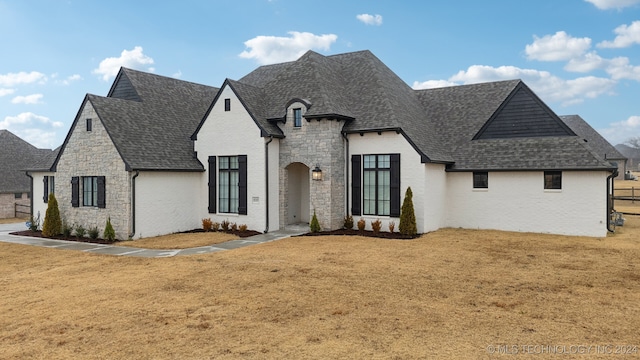 french country inspired facade featuring a front lawn