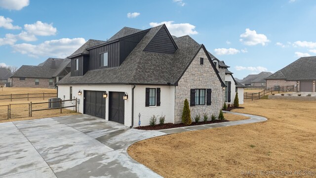 view of front of home with a front yard, a garage, and cooling unit