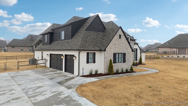 view of front of home with driveway, a shingled roof, central AC unit, fence, and a front lawn