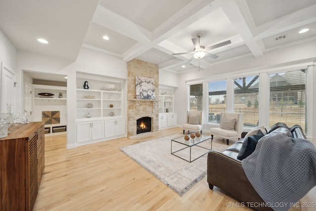 living room featuring coffered ceiling, a fireplace, visible vents, and light wood-style floors