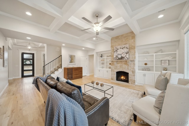 living room featuring baseboards, coffered ceiling, stairway, beamed ceiling, and light wood-type flooring