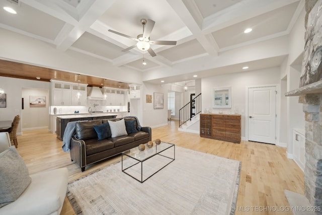 living area featuring light wood finished floors, stairway, coffered ceiling, and beam ceiling