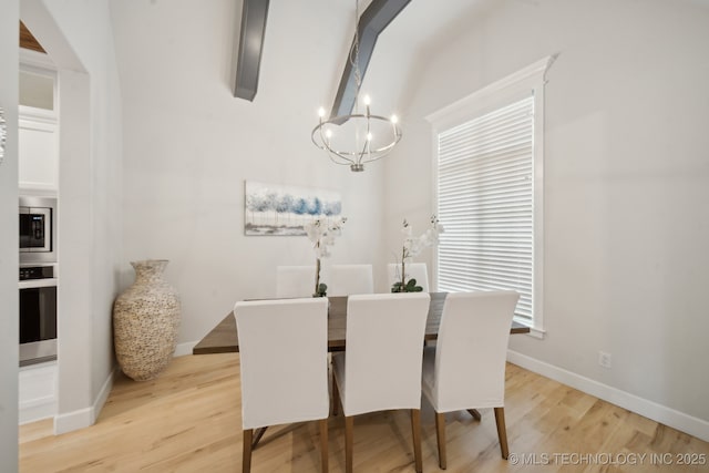 dining room featuring light wood finished floors, baseboards, and a chandelier