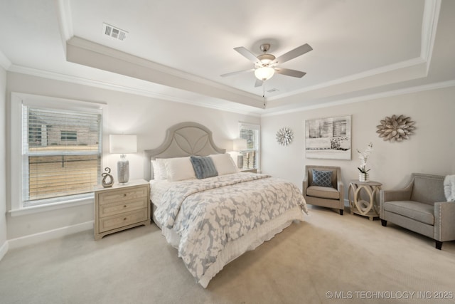 bedroom with ornamental molding, visible vents, a raised ceiling, and light colored carpet