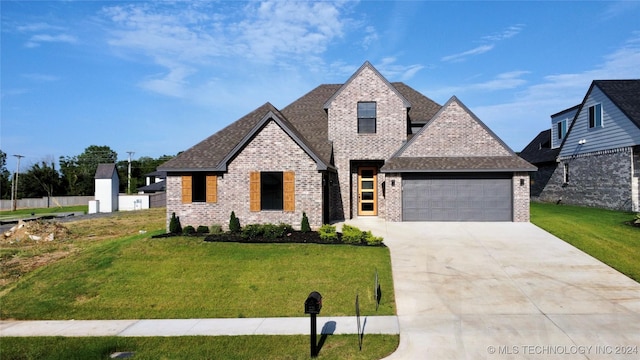 french country inspired facade featuring a front lawn and a garage