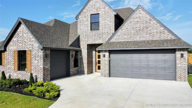 view of front of property with central AC and a garage