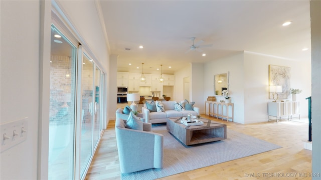 living room featuring ceiling fan and light hardwood / wood-style flooring