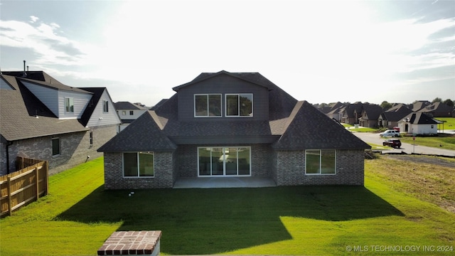 back of property with a yard and a patio