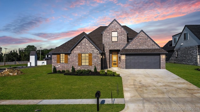 view of front of property with a garage and a lawn