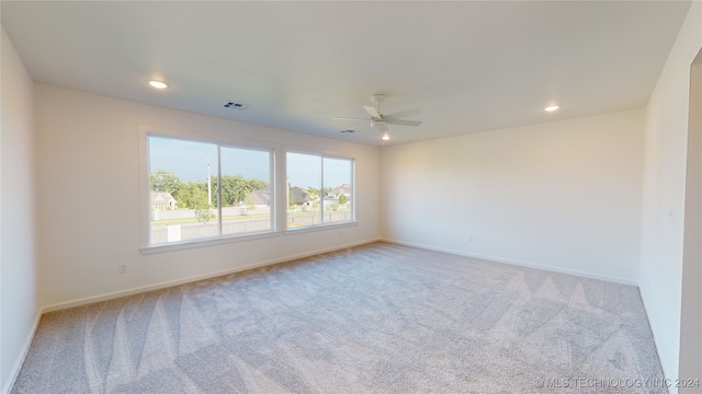 unfurnished room featuring light colored carpet and ceiling fan