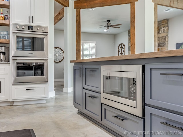 kitchen featuring gray cabinets, white cabinetry, ceiling fan, and stainless steel appliances