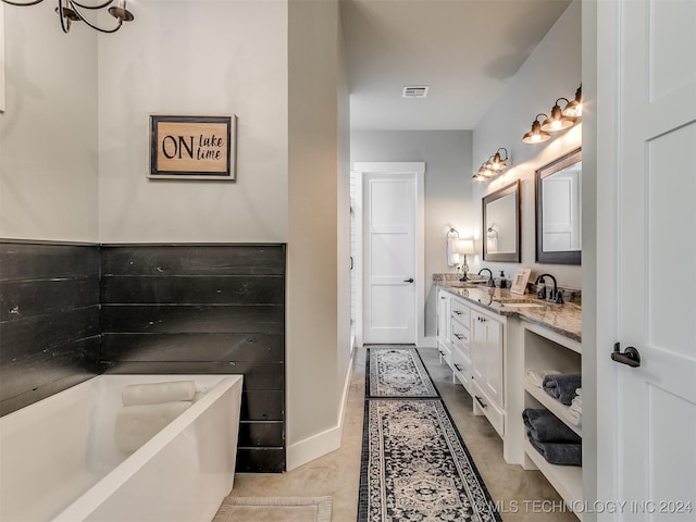 bathroom featuring tile patterned flooring, vanity, a tub, and a notable chandelier