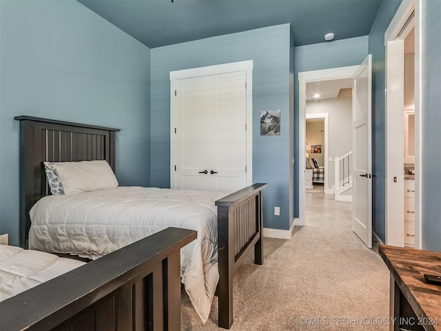 bedroom with light carpet and a closet