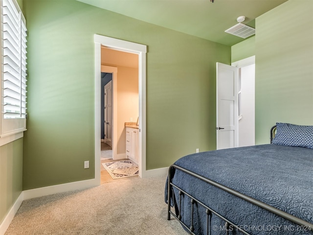 carpeted bedroom featuring ensuite bathroom