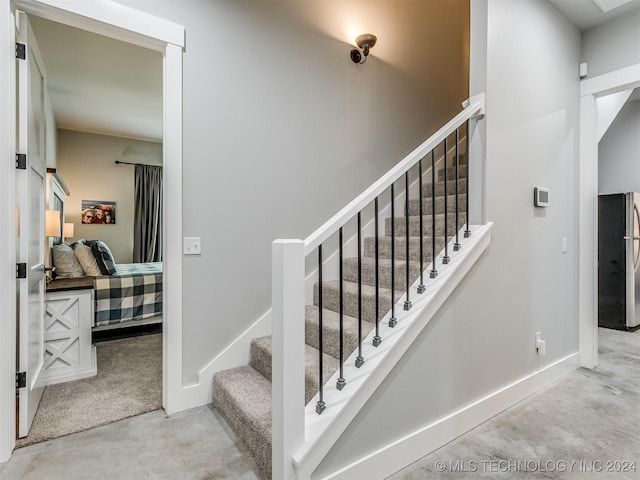 staircase featuring concrete flooring