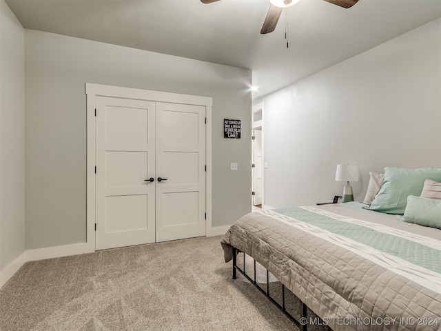 bedroom with ceiling fan, a closet, and light carpet