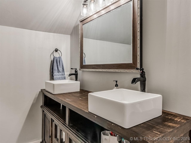 bathroom featuring vanity and lofted ceiling