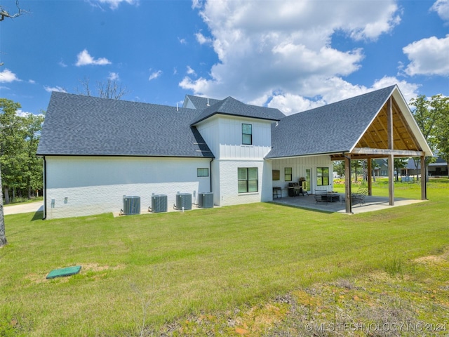 back of house with central AC unit, a patio area, and a lawn