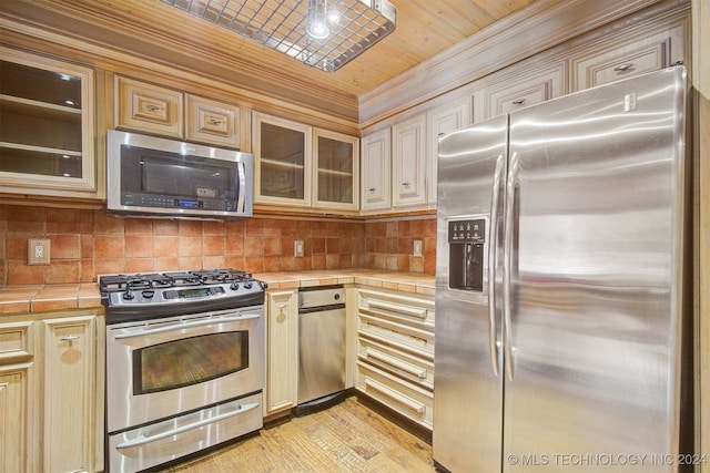 kitchen with tile counters, wooden ceiling, light hardwood / wood-style flooring, backsplash, and appliances with stainless steel finishes