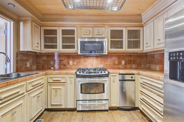 kitchen featuring backsplash, sink, appliances with stainless steel finishes, tile counters, and wood ceiling