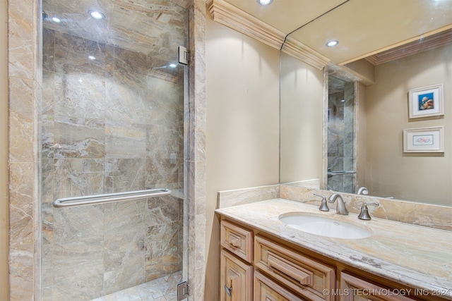 bathroom with vanity, a shower with door, and ornamental molding