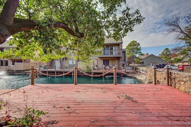 dock area featuring a water view and a balcony