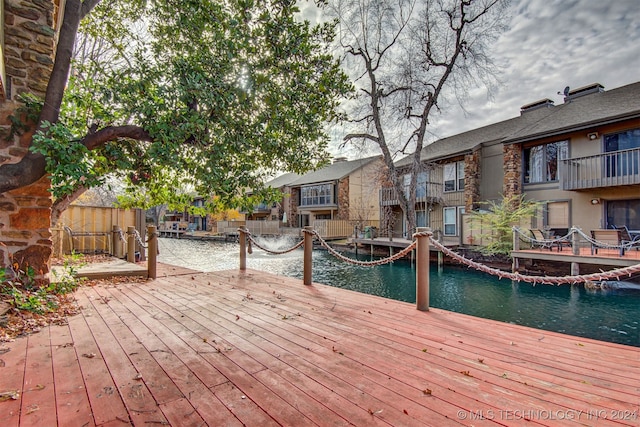 wooden deck with a water view and a boat dock