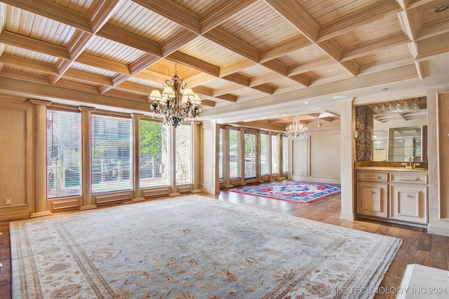 unfurnished sunroom featuring plenty of natural light, wood ceiling, sink, and a chandelier