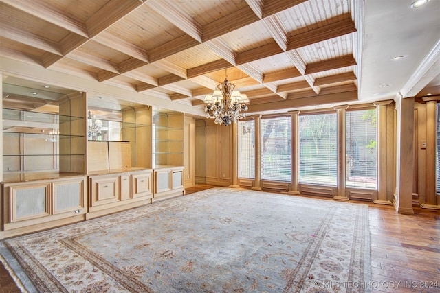 interior space with ornate columns, coffered ceiling, wooden ceiling, a notable chandelier, and beamed ceiling