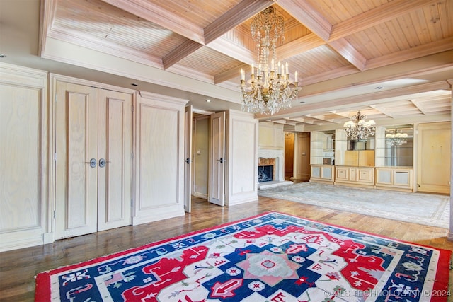 interior space featuring wooden ceiling, wood-type flooring, ornamental molding, and an inviting chandelier