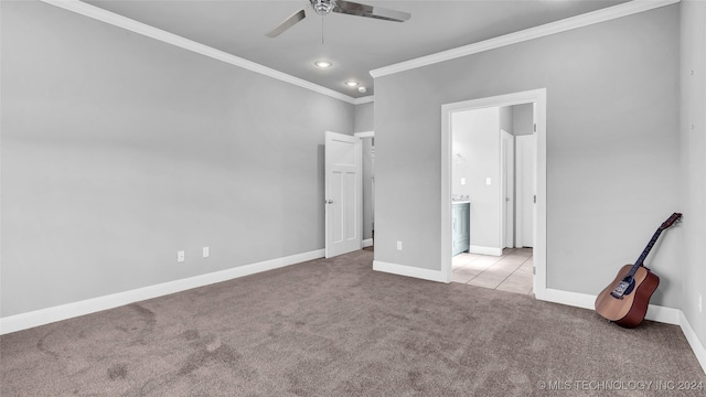 unfurnished bedroom featuring ceiling fan, light colored carpet, crown molding, and connected bathroom