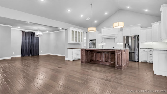 kitchen with a center island, white cabinets, hanging light fixtures, appliances with stainless steel finishes, and tasteful backsplash