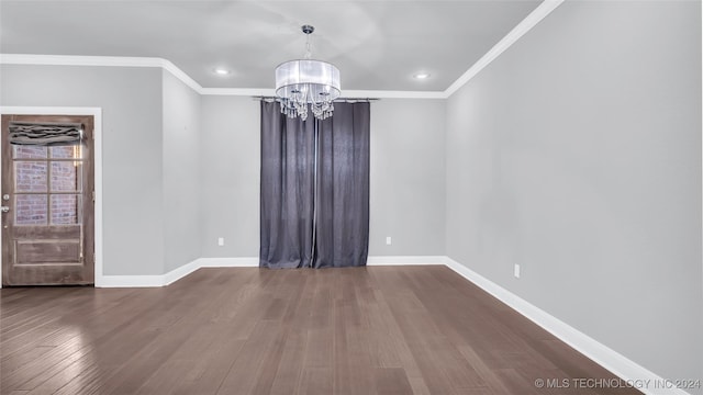 spare room with hardwood / wood-style floors, a notable chandelier, and crown molding