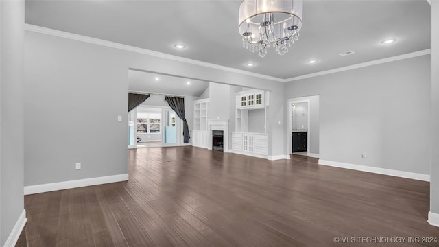 unfurnished living room featuring dark hardwood / wood-style flooring, built in features, a chandelier, and ornamental molding