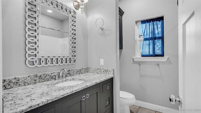 bathroom featuring tile patterned flooring, vanity, toilet, and a shower