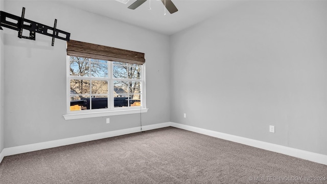 carpeted spare room featuring ceiling fan