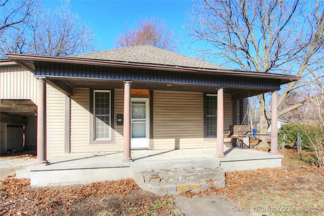 rear view of house featuring covered porch