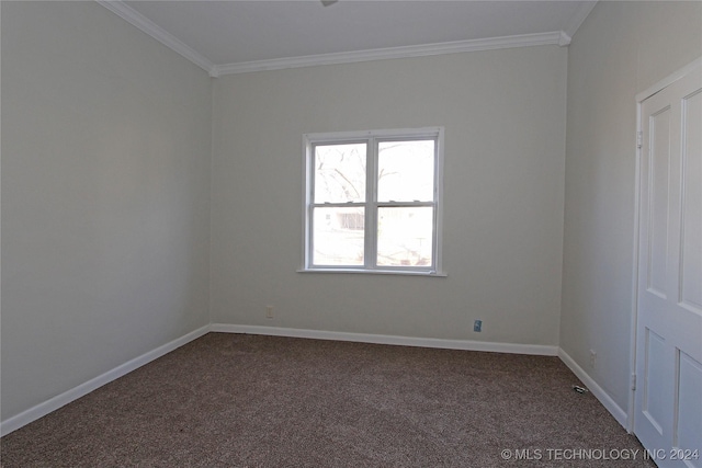 spare room with crown molding and dark colored carpet