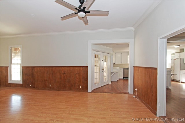 spare room featuring french doors, light hardwood / wood-style floors, ceiling fan, and ornamental molding