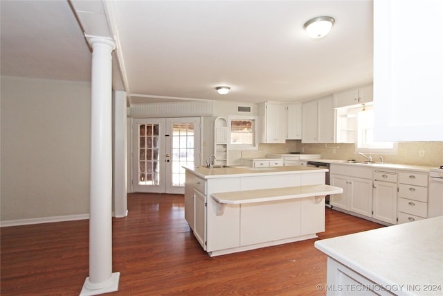 kitchen with white cabinets, dark hardwood / wood-style floors, sink, and an island with sink