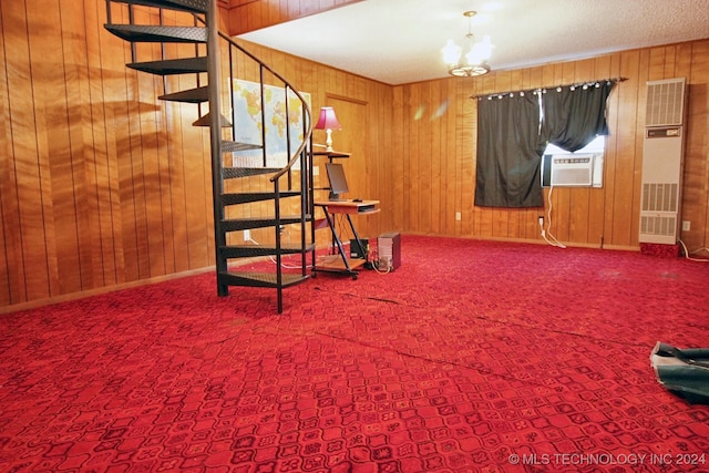 interior space featuring carpet, wooden walls, cooling unit, and an inviting chandelier