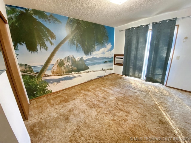 carpeted spare room featuring a wall mounted air conditioner and a textured ceiling