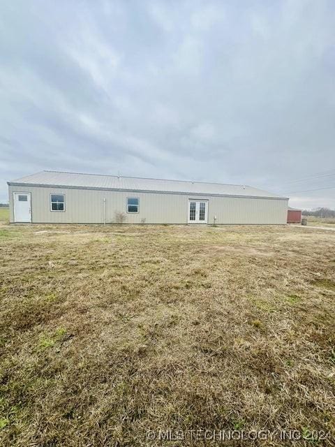 rear view of property featuring a lawn and an outdoor structure