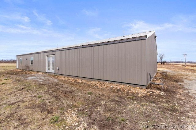 view of side of property featuring metal roof and french doors