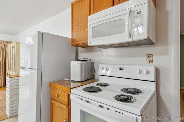 kitchen featuring light hardwood / wood-style flooring and white appliances