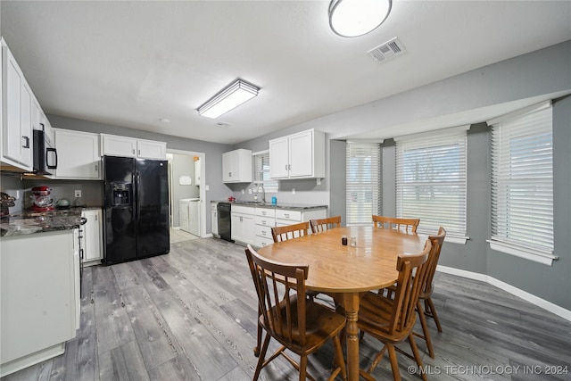 dining space with hardwood / wood-style flooring, sink, and independent washer and dryer