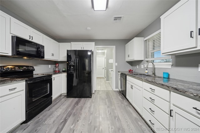 kitchen featuring sink, white cabinetry, dark stone countertops, light hardwood / wood-style floors, and black appliances