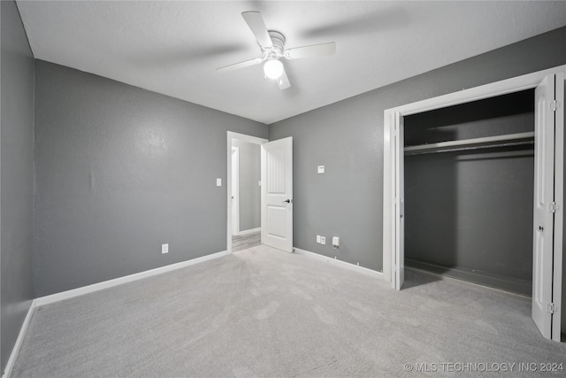 unfurnished bedroom featuring light colored carpet, a closet, and ceiling fan