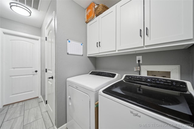 laundry room with cabinets and washing machine and dryer